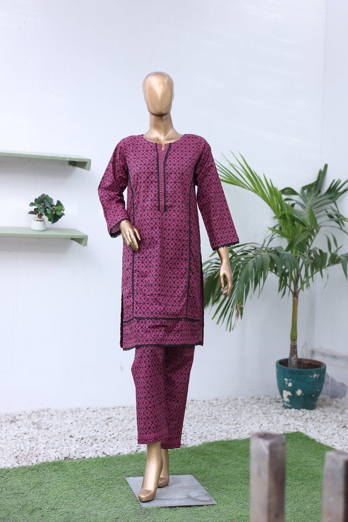 Mannequin wearing a purple outfit with a white background and plants.
