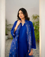 Woman wearing a royal blue traditional outfit with a matching dupatta indoors.
