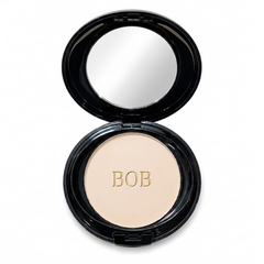 Close-up texture of BOB Maxibell oil-free matte pressed powder alongside its soft sponge applicator.