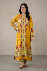 Woman wearing a yellow patterned dress against a plain background