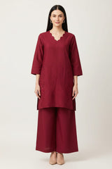 Woman wearing a maroon outfit with a plain background