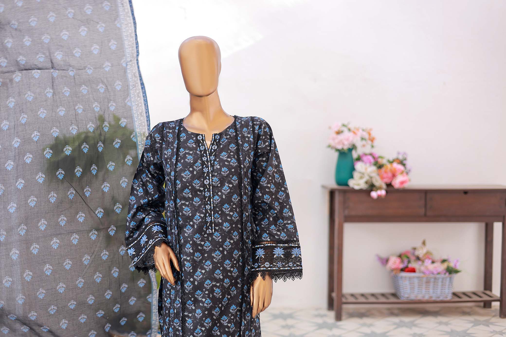 Mannequin wearing a dark floral dress with a light-colored background