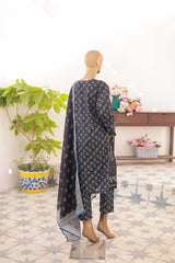 Mannequin wearing a dark floral dress with a matching dupatta in a room with plants and flowers.
