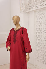 Red dress with black embroidery on a mannequin against a decorative white wall.