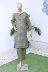 Mannequin wearing a green patterned dress with decorative elements on a white background