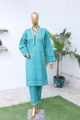 Teal jacket on a mannequin with gold shoes against a white background