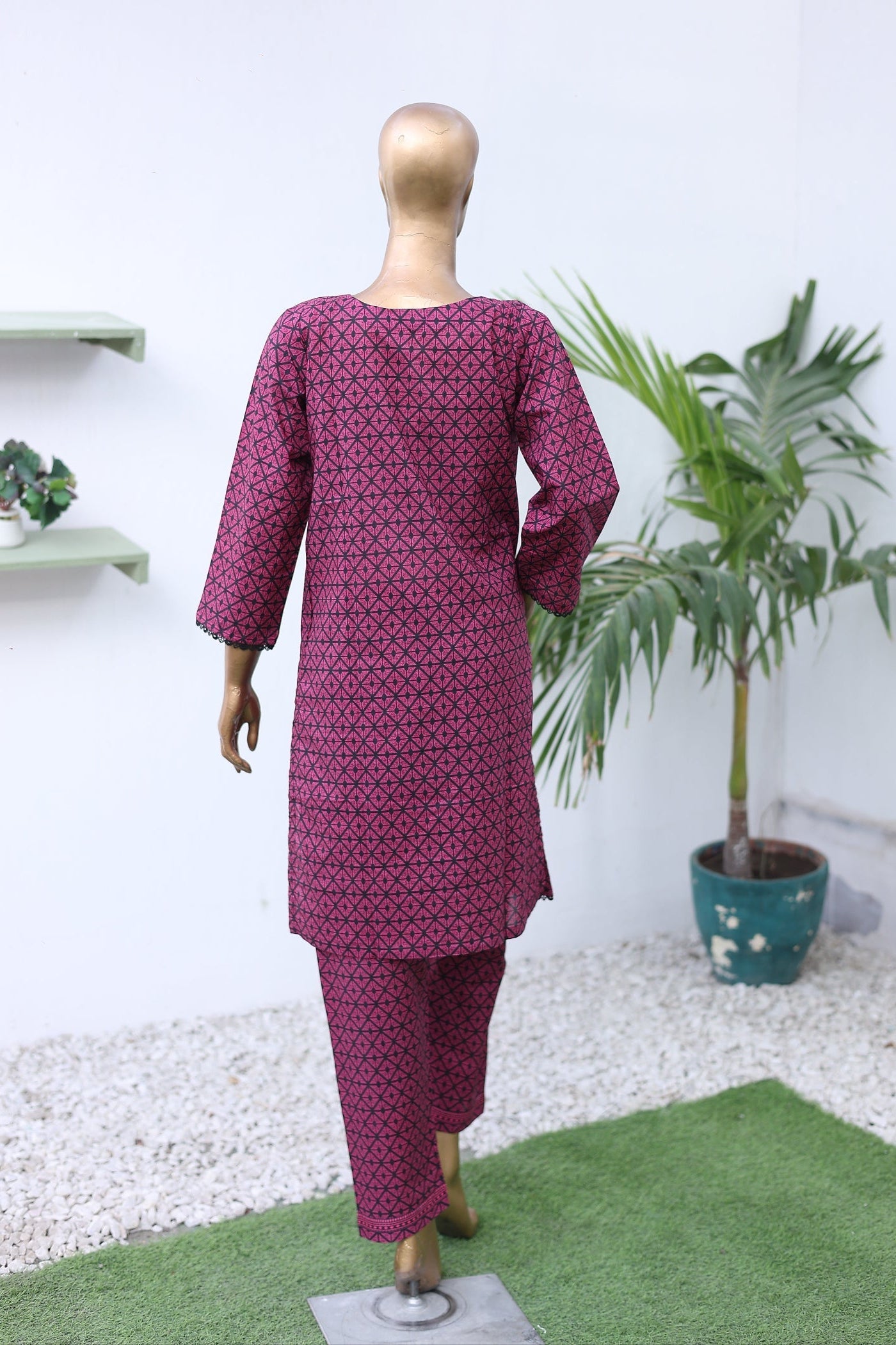 Mannequin wearing a purple outfit with a white background and plants.