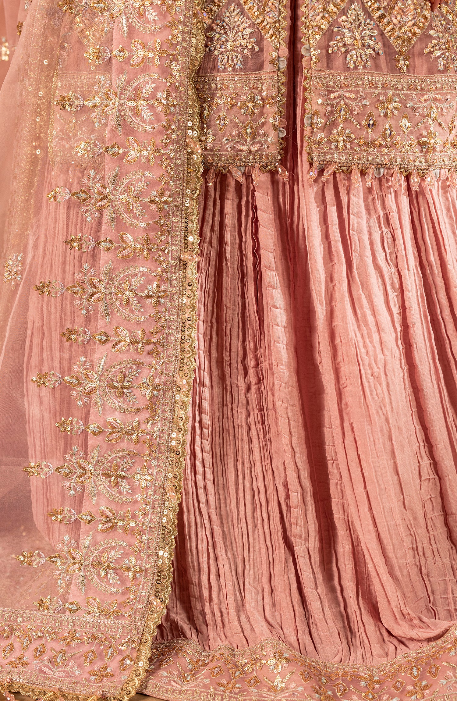 Close-up of a pink traditional outfit with gold embroidery