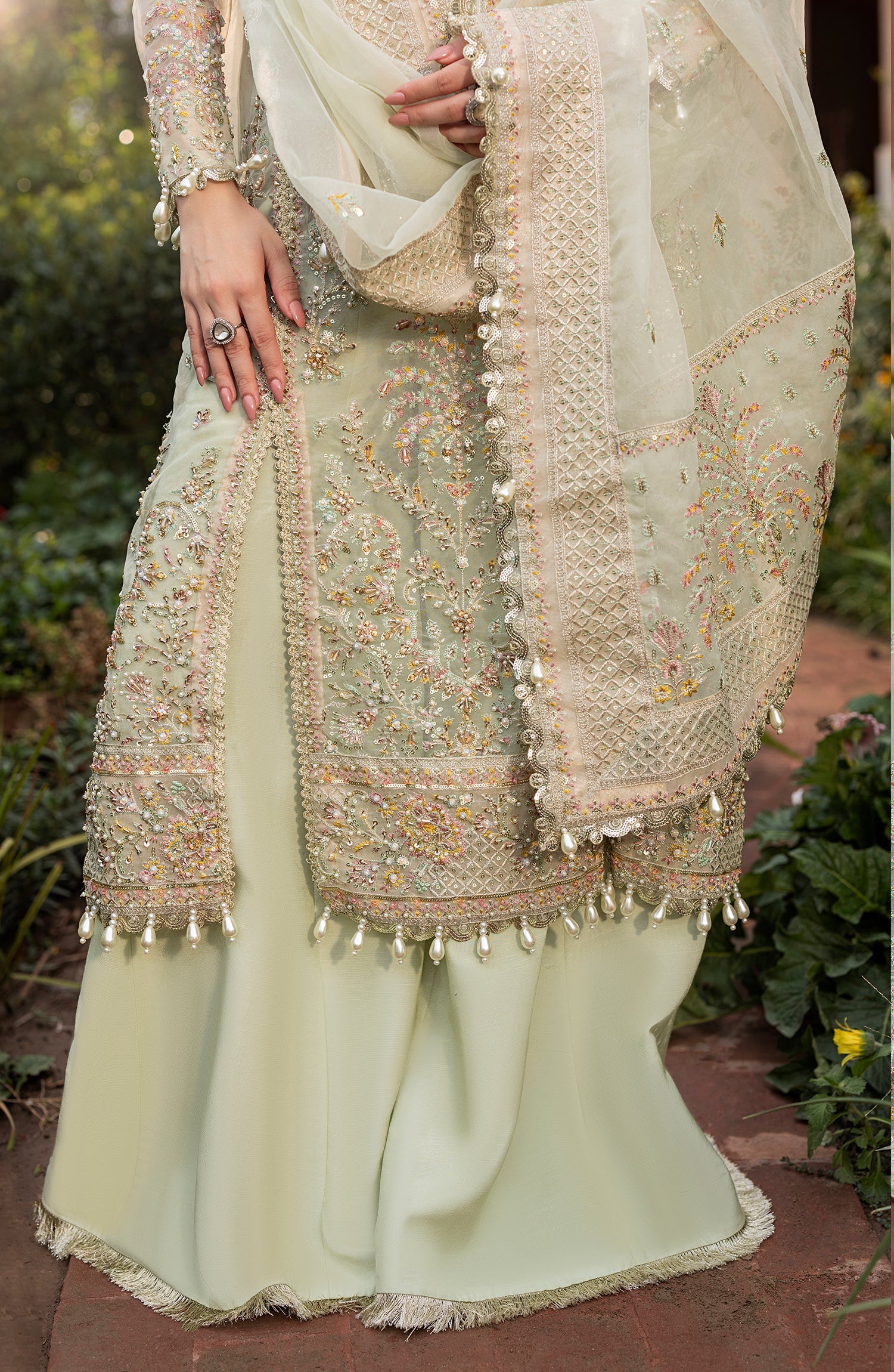 Traditional outfit with intricate embroidery and embellishments in a natural setting.